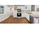 Updated kitchen showcases white cabinets, hardwood floors, modern appliances at 3395 W Union Ave, Englewood, CO 80110