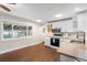 Sunlit kitchen featuring hardwood floors, white cabinets, stainless appliances at 3395 W Union Ave, Englewood, CO 80110
