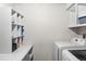 Functional laundry area equipped with modern washer and dryer units, built-in shelving, and ample storage at 3395 W Union Ave, Englewood, CO 80110
