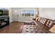 Bright living room featuring hardwood floors, a tufted leather sofa, and a large window at 3395 W Union Ave, Englewood, CO 80110