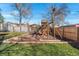 Backyard with a wooden playground area and a trampoline, perfect for children and outdoor activities at 3395 W Union Ave, Englewood, CO 80110