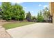 Large concrete patio and well-manicured backyard featuring mature trees and landscaping at 13262 Elizabeth St, Thornton, CO 80241
