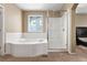 Bright bathroom features a walk-in shower, soaking tub, and window at 13262 Elizabeth St, Thornton, CO 80241