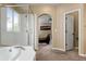 Bright bathroom features a walk-in shower, soaking tub, and entrance to bedroom at 13262 Elizabeth St, Thornton, CO 80241