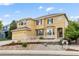 Inviting two-story home featuring a two-car garage, stone accents, bay windows, and a landscaped front yard at 13262 Elizabeth St, Thornton, CO 80241