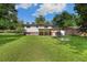 Backyard view of a two-story home showcasing lush greenery, a patio, and mature shade trees at 5193 Zinnia St, Arvada, CO 80002