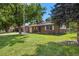Traditional home with a well-manicured lawn, mature trees, and a brick facade at 5193 Zinnia St, Arvada, CO 80002