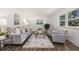 Bright living room featuring hardwood floors, plush seating, and natural light from a large window at 5193 Zinnia St, Arvada, CO 80002