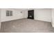 Finished basement space with plush gray carpeting, a window and a stylish black brick fireplace at 5401 E Dakota Ave # 22, Denver, CO 80246