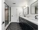 Bathroom featuring black hexagon tile floors, double sink vanity, and a glass shower at 5401 E Dakota Ave # 22, Denver, CO 80246