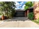 Attached two-car garage with a neutral color door, concrete driveway, and brick facade details at 5401 E Dakota Ave # 22, Denver, CO 80246