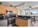 Kitchen featuring stainless steel oven, tile backsplash, wood cabinets, and an eat in breakfast bar at 909 N Logan St # 11A, Denver, CO 80203
