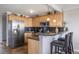 Open kitchen with stainless steel refrigerator, breakfast bar, tile floors, and ample counter space at 909 N Logan St # 11A, Denver, CO 80203