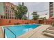 Outdoor pool with lounging area, surrounded by decorative planters and exterior building view at 909 N Logan St # 11A, Denver, CO 80203