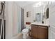 Bright bathroom features modern vanity, framed mirror and stylish striped shower curtain at 9624 Dunning Cir, Highlands Ranch, CO 80126