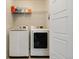 Clean, efficient laundry room includes a washer, dryer, and overhead shelving at 9624 Dunning Cir, Highlands Ranch, CO 80126
