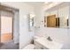 Bathroom with vanity, sink, tiled walls, mirror, toilet, and view to other rooms at 2070 Kingston St, Aurora, CO 80010