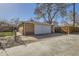 Two car detached brick garage with white doors is behind a fenced lot with a concrete driveway at 2070 Kingston St, Aurora, CO 80010