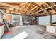 Spacious garage interior features exposed wood rafters, concrete floor, peg boards and built in shelving at 2070 Kingston St, Aurora, CO 80010