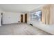 Bright living room featuring neutral carpet, fresh white paint, and a large window to enjoy the outside light at 2070 Kingston St, Aurora, CO 80010