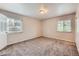 Bedroom with carpeted floors, two windows providing natural light, and neutral-toned walls at 679 S Pearl St, Elizabeth, CO 80107