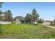 Lush green yard featuring a well-maintained lawn and mature trees surrounding the house at 679 S Pearl St, Elizabeth, CO 80107