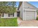 Home exterior showcases a clean gray facade, attached garage, and well-manicured lawn with mature trees at 679 S Pearl St, Elizabeth, CO 80107