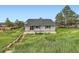 Back of house featuring a light gray exterior, patio, sliding glass doors, and well-maintained yard at 679 S Pearl St, Elizabeth, CO 80107