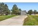 Charming home with a long driveway, mature trees, and attached garage at 679 S Pearl St, Elizabeth, CO 80107