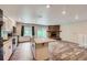 Open floor plan showcasing the kitchen island leading to a stone fireplace at 679 S Pearl St, Elizabeth, CO 80107