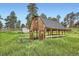 Exterior view of rustic barn in grassy field under blue sky at 679 S Pearl St, Elizabeth, CO 80107