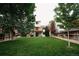 Expansive backyard with lush green grass, mature trees, and a deck, creating a serene outdoor space at 17530 E Caspian Pl, Aurora, CO 80013