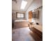 Bathroom with a skylight, soaking tub, light grey tile, and modern vanity with vessel sink at 17530 E Caspian Pl, Aurora, CO 80013