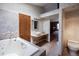 Bathroom with a soaking tub, double vanity, light grey tile, and modern fixtures at 17530 E Caspian Pl, Aurora, CO 80013