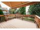 Spacious wood deck with awning overlooks a well-manicured backyard and lush greenery, perfect for outdoor entertaining at 17530 E Caspian Pl, Aurora, CO 80013