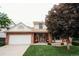 Charming two-story brick home with a well-manicured lawn and inviting front porch at 17530 E Caspian Pl, Aurora, CO 80013