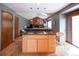 Kitchen with island cooktop and open view to living room and fireplace at 17530 E Caspian Pl, Aurora, CO 80013