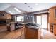 Open-concept living room and kitchen with high ceilings, brick fireplace, and natural light from skylights at 17530 E Caspian Pl, Aurora, CO 80013