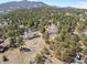 An aerial view of a gorgeous home surrounded by tall trees and a lush forest landscape at 2999 Olympia Cir, Evergreen, CO 80439