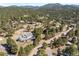 An aerial view of a gorgeous home surrounded by tall trees and a lush forest landscape at 2999 Olympia Cir, Evergreen, CO 80439