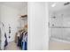 Modern bathroom featuring tiled walls, glass shower, and closet with wire shelving at 2999 Olympia Cir, Evergreen, CO 80439