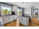 Bright kitchen features white cabinets, modern appliances, hardwood floors, and a scenic backyard view at 2999 Olympia Cir, Evergreen, CO 80439