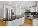 Spacious kitchen with white cabinets, stainless steel appliances, dark granite countertops, and wood floors at 2999 Olympia Cir, Evergreen, CO 80439