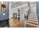 Bright living room featuring fireplace, an open staircase, and hardwood floors at 2999 Olympia Cir, Evergreen, CO 80439