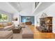 Bright living room with a stone fireplace, hardwood floors, and large windows for natural light at 2999 Olympia Cir, Evergreen, CO 80439