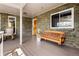 Quaint front porch with a hanging bench, brick accents and a wooden front door at 12941 W 75Th Ave, Arvada, CO 80005