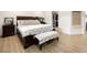 Serene main bedroom with a wooden sleigh bed, soft textures, hardwood floors, and a glimpse into the closet at 12941 W 75Th Ave, Arvada, CO 80005
