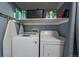 Laundry area with modern washer and dryer units, plus storage shelf at 4896 S Dudley St # 5-5, Littleton, CO 80123