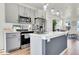 Bright kitchen with stainless steel appliances, a central island, and a view of the living area at 18284 E 49Th Pl, Denver, CO 80249