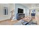 A cozy living room with modern hardwood floors, a TV, a staircase, and lots of natural light at 18284 E 49Th Pl, Denver, CO 80249